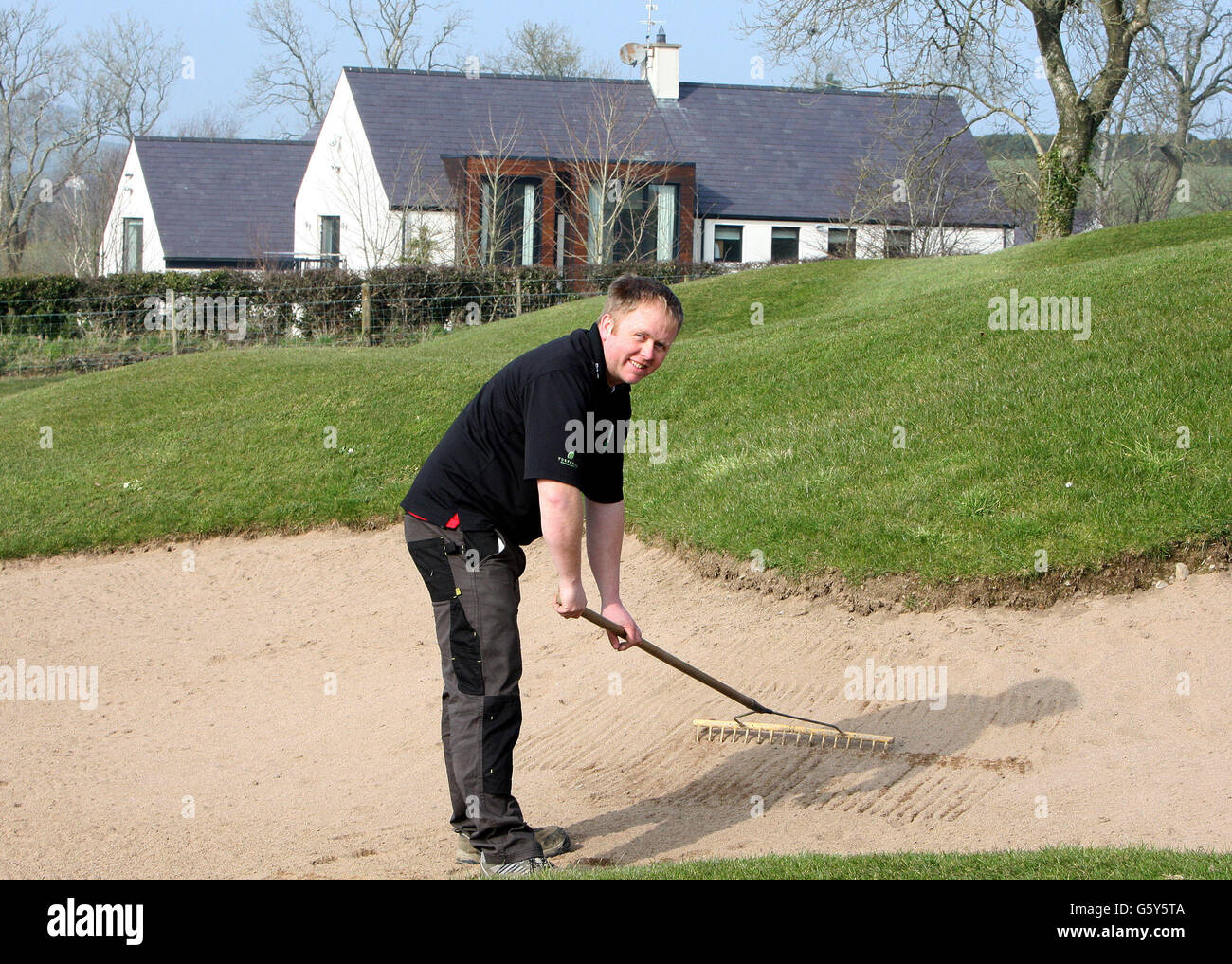 Il guardiano verde Barry Kavanagh di fronte alla ex casa del golfista Rory McIlroy a Moneyreagh, Co Down che è stato venduto. Foto Stock