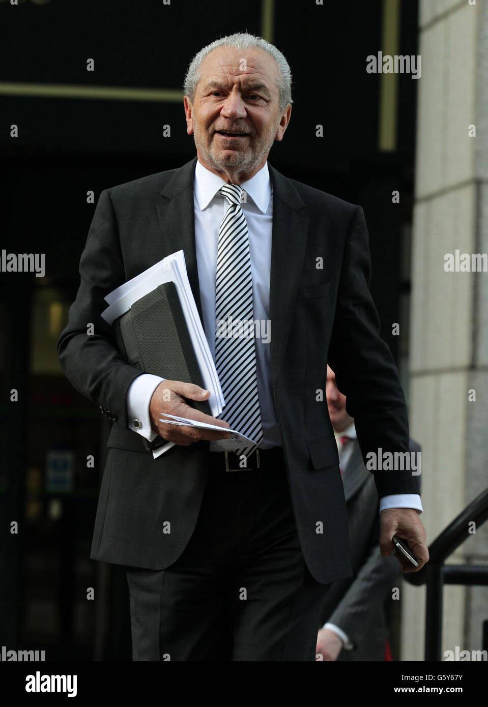Lord Sugar lascia a seguito di una costruttiva audizione di licenziamento contro di lui presso un East London Employment Tribunal Service presso la Anchorage House, nel East India Quay, Londra. Foto Stock