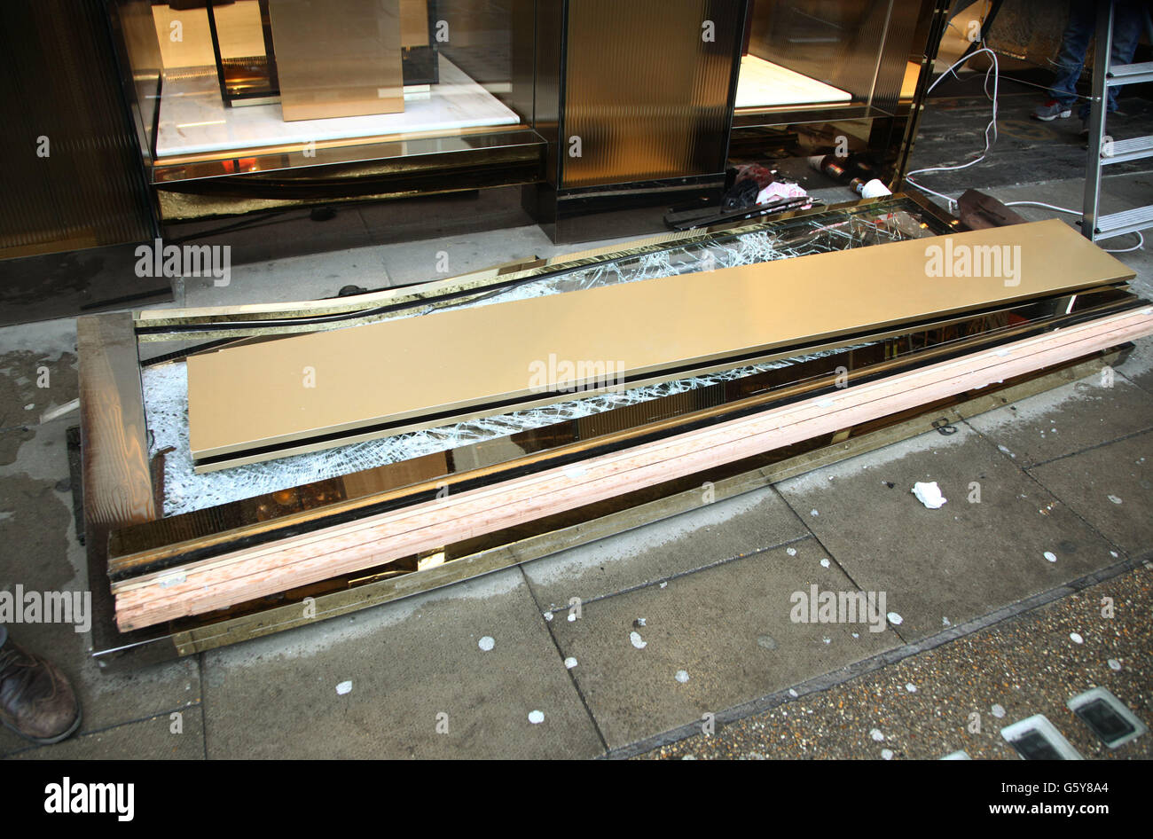 Una delle porte è stata rimossa dall'ingresso danneggiato del negozio Gucci su Sloane Street, a ovest di Londra, dopo un'incursione smash e grab la notte scorsa. Foto Stock