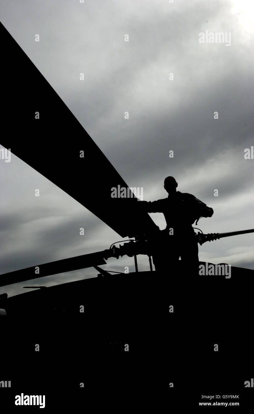 Un pilota di elicottero americano Black Hawk guarda sulle lame della rota al Farnborough Airshow, Hampshire. Foto Stock