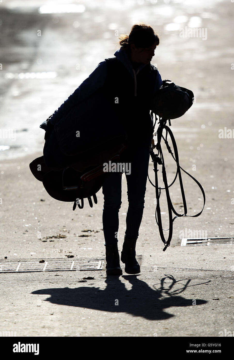 Un ragazzo stabile muove le attrezzature intorno alle scuderie prima di correre il giovedì di San Patrizio al Cheltenham Festival 2013 all'ippodromo di Cheltenham, Gloucestershire. Foto Stock