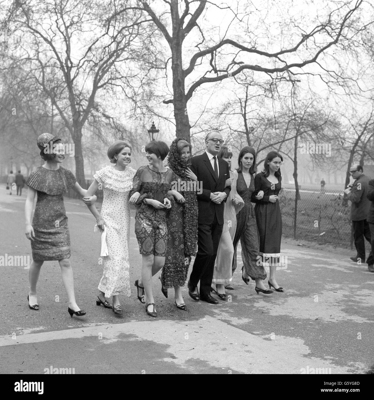 Il Duca di Bedford cammina braccio in braccio con alcuni dei modelli del Berkeley Debutante Dress Show. Da sinistra: Sally Stainforth, Eugenie Vivian, Elizabeth Hopton, Karen Broderick, Felicity Loxton-Peacock, Amanda Collingwood e Marion Eton. Foto Stock