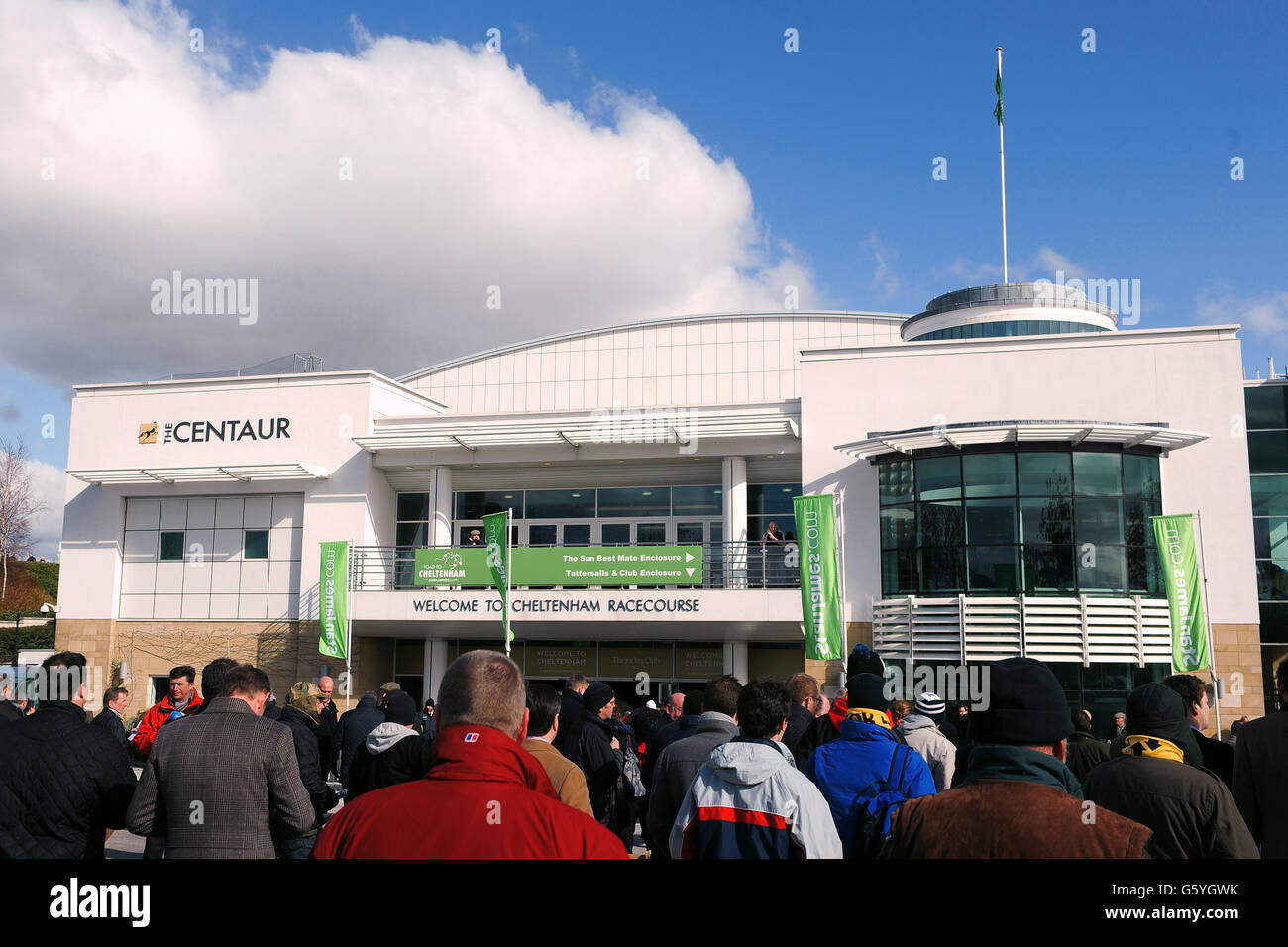 La gente entra nell'edificio principale durante il Champion Day del Cheltenham Festival 2013 all'ippodromo di Cheltenham, Gloucestershire. Foto Stock