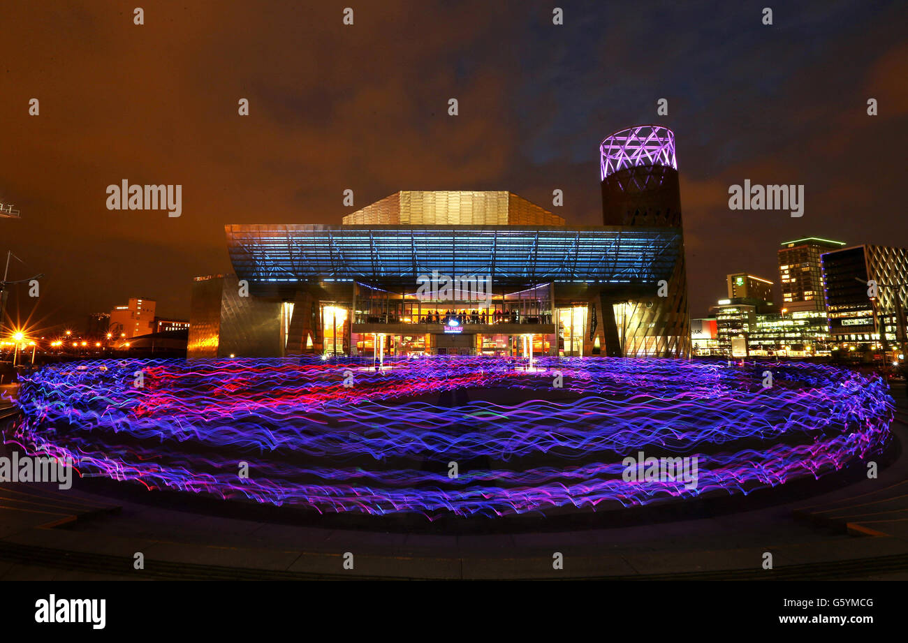 Centinaia di joggers, che indossano abiti speciali con luci a LED attaccate, arrivano fuori dal Lowry Theatre di Salford Quays, Greater Manchester. Circa 400 corridori hanno partecipato a una prova di abbigliamento per la performance dà diritto a Speed of Light. Creato da NVA, ente di beneficenza delle arti pubbliche, il display utilizza una tecnologia all'avanguardia per trasformare i corridori in lucciole umane, fissando una serie di LED alle articolazioni, agli arti e alle teste dei corpi in movimento. Foto Stock