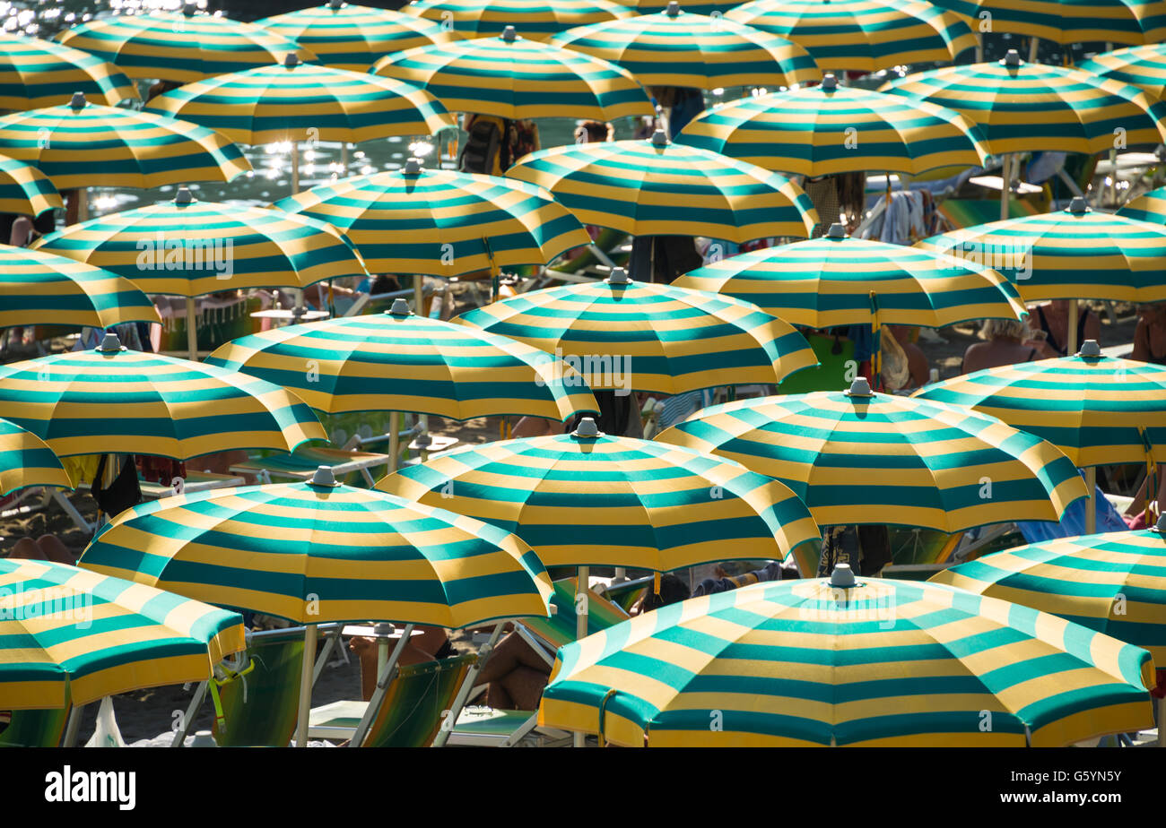 Infilate a strisce colorate ombrelloni sulla spiaggia, Sestri Levante, Liguria, Italia Foto Stock