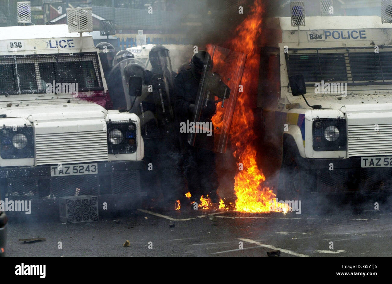 Polizia dopo essere stata colpita da una bomba a benzina sulla Springfield Road, a ovest di Belfast. La polizia ha sofferto una sbarramento di bombe a benzina, fuochi d'artificio e mattoni dopo che gli ufficiali hanno sparato un bastone di plastica ai dimostranti che hanno attaccato una parata di ordine arancione in un'area nazionalista. * i problemi sono iniziati quando i manifestanti cattolici hanno visto Orangemen salire su una parte contesa della Springfield Road. Foto Stock