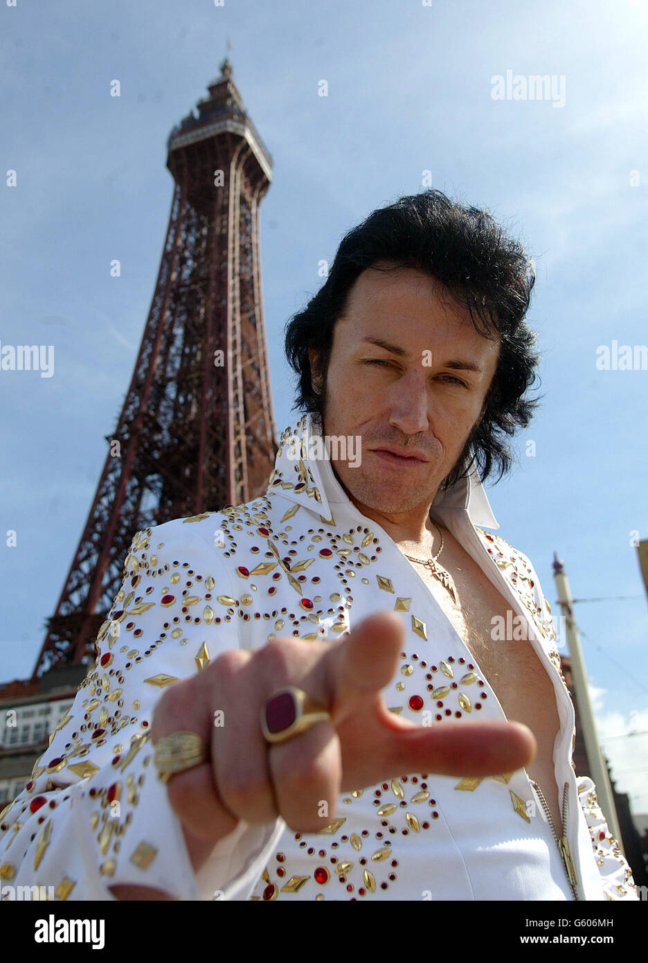 Michael King, artista di Elvis Tribute, sulla passeggiata con la torre Blackpool (sullo sfondo) a Blackpool durante l'inizio dell'esperienza Elvis che si svolge presso i Winter Gardens di Blackpool, il 25° anniversario della morte di Presley. *....il fine settimana Elvis Experience a Blackpool, si prevede di attrarre migliaia di fan di elvis nella città di mare per rendere omaggio a Presley. Foto Stock