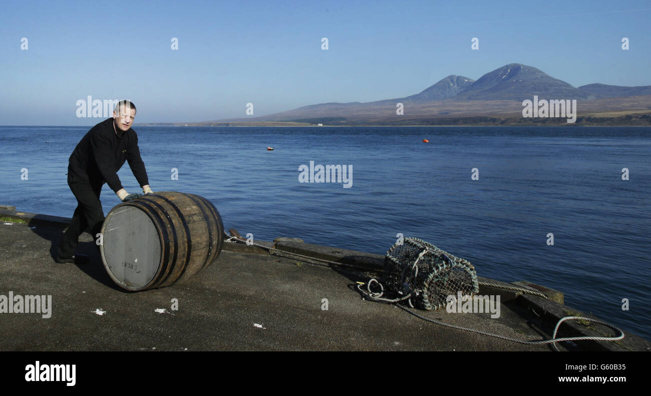 L'operatore Bobby Wright sposta un vecchio barile di whisky presso la distilleria di whisky Caol Ila sull'isola scozzese di Islay. I migliori frullatori di tutto il mondo si incontreranno in Scozia il mese prossimo alla ricerca del miglior whisky dell'anno. Foto Stock