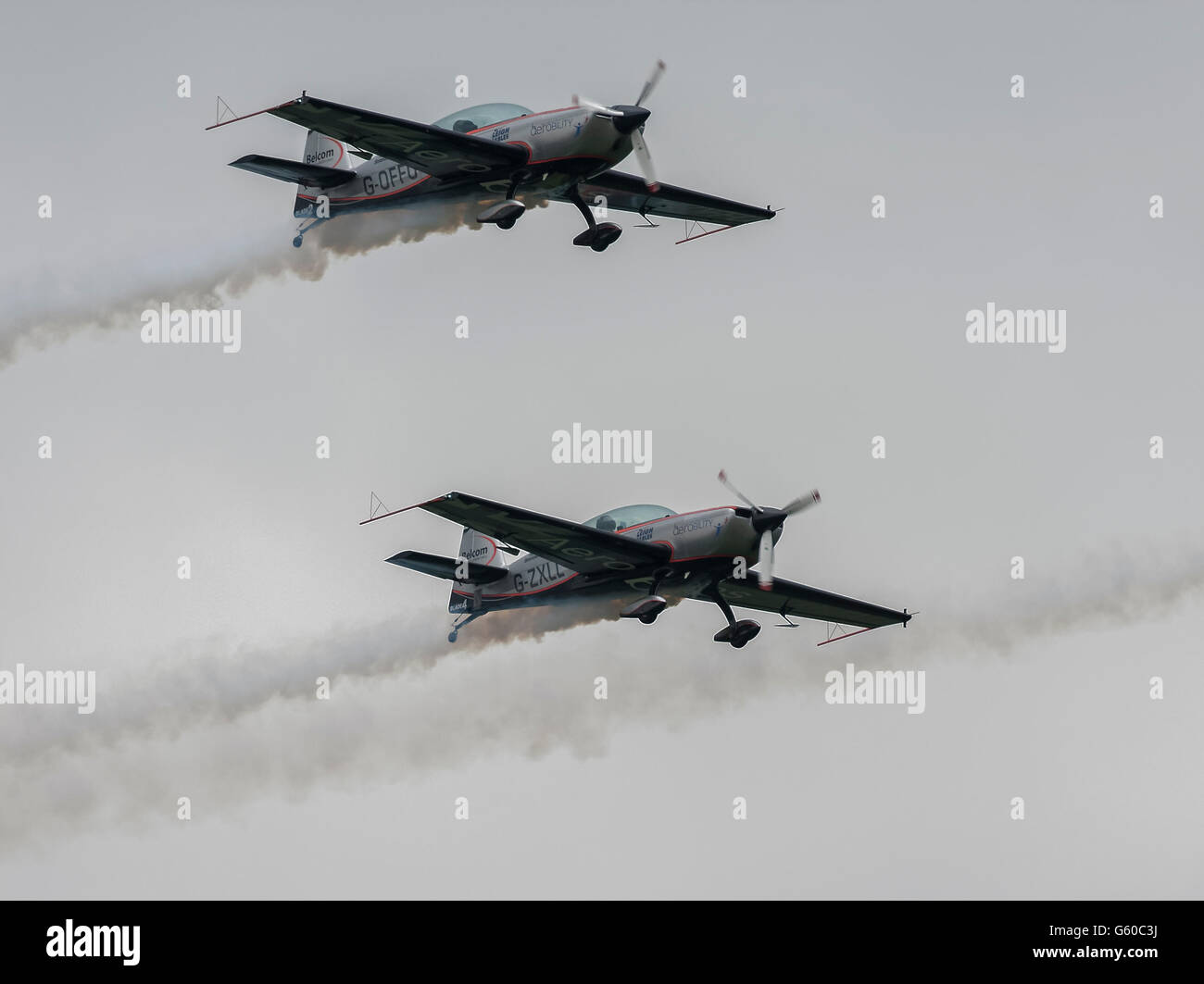 Due piani dalle pale Aerobatic Team Display battenti con emissione di fumo bianco sentieri nel cielo sopra Biggin Hill Air Show Foto Stock