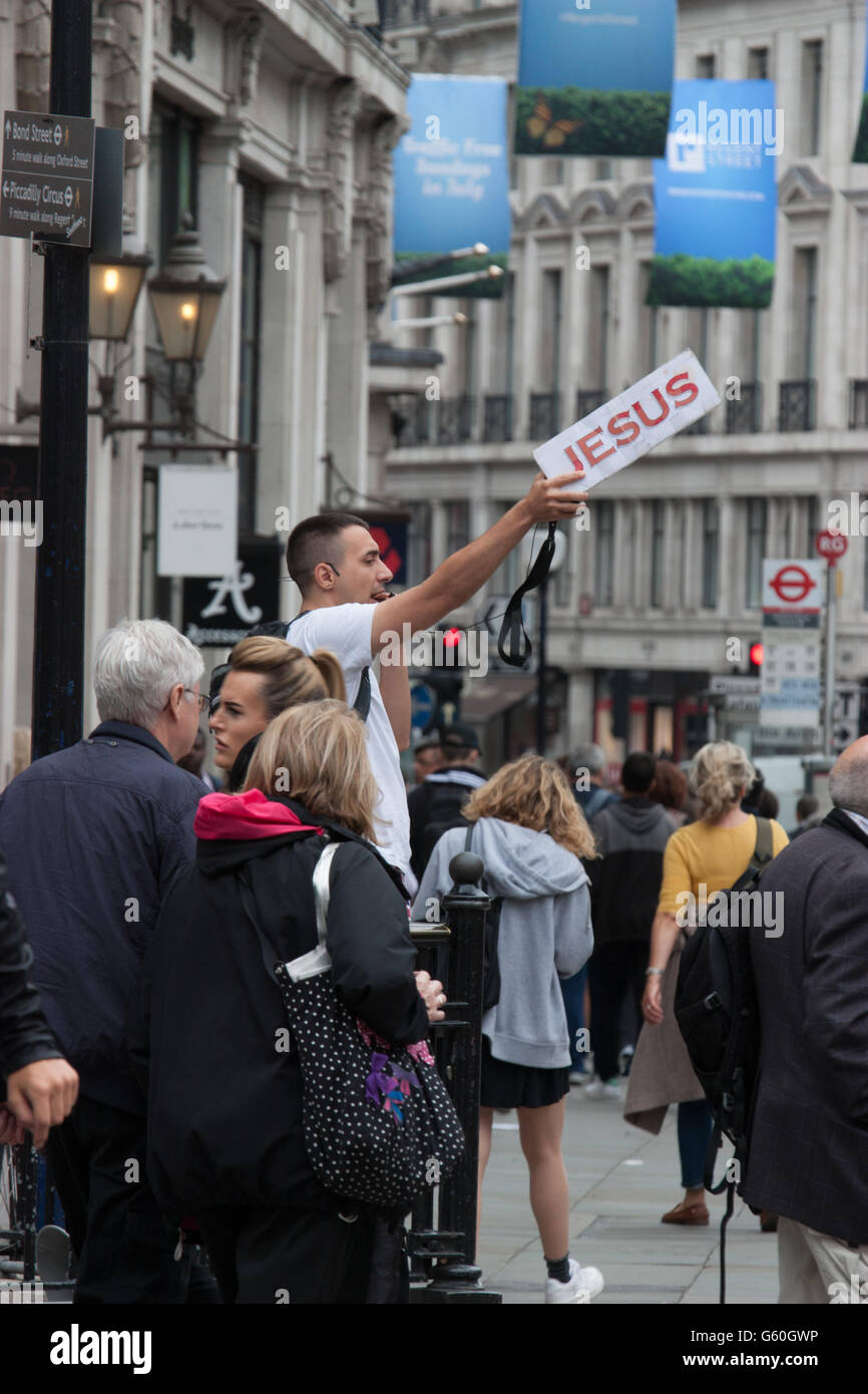 Predicatore religioso con Gesù poster predicazione in Oxford Street Londra Foto Stock