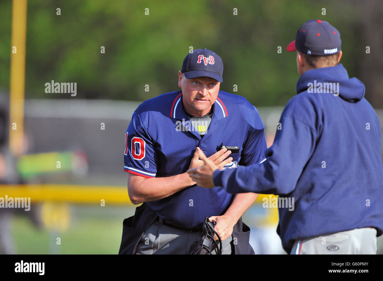 Coach sostenendo una chiamata e la richiesta di una spiegazione da parte di un arbitro durante una scuola di gioco di baseball. Stati Uniti d'America. Foto Stock