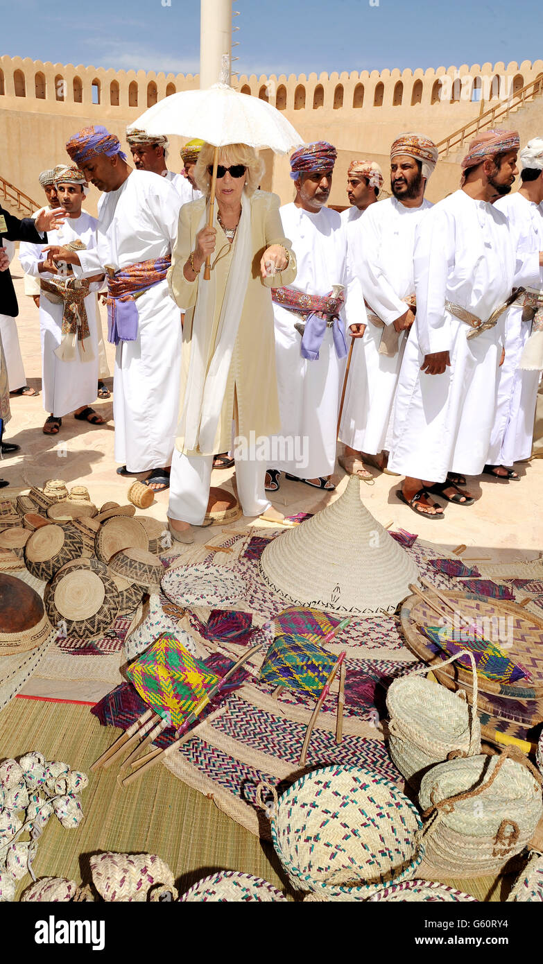 La Duchessa di Cornovaglia guarda i cesti di tessitura di un uomo locale, e ne sceglie alcuni da acquistare, durante la visita reale del Forte di Nizwa il giorno due del loro tour di Oman. Foto Stock