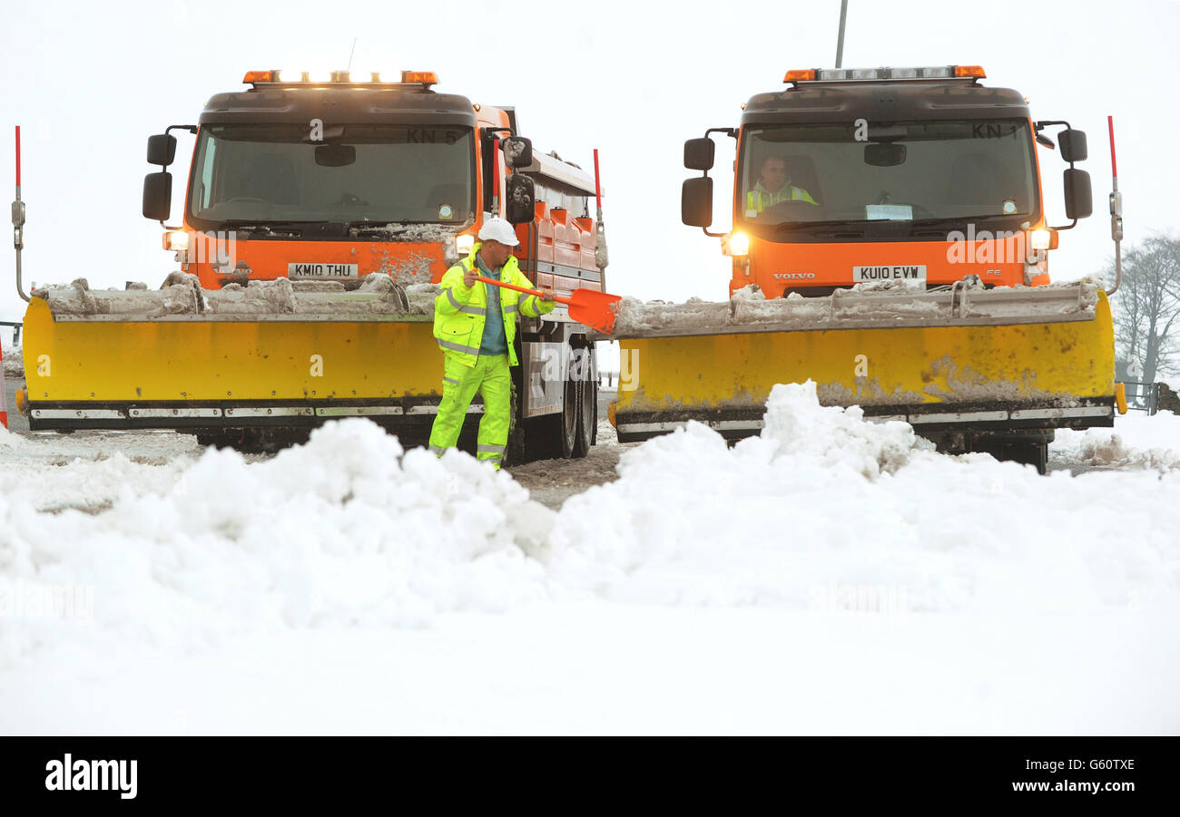 Un uomo libera gli aratri di neve sulla A66 vicino a Bowes, Co Durham dove la strada è stata chiusa per diverse ore a causa della neve pesante. Foto Stock