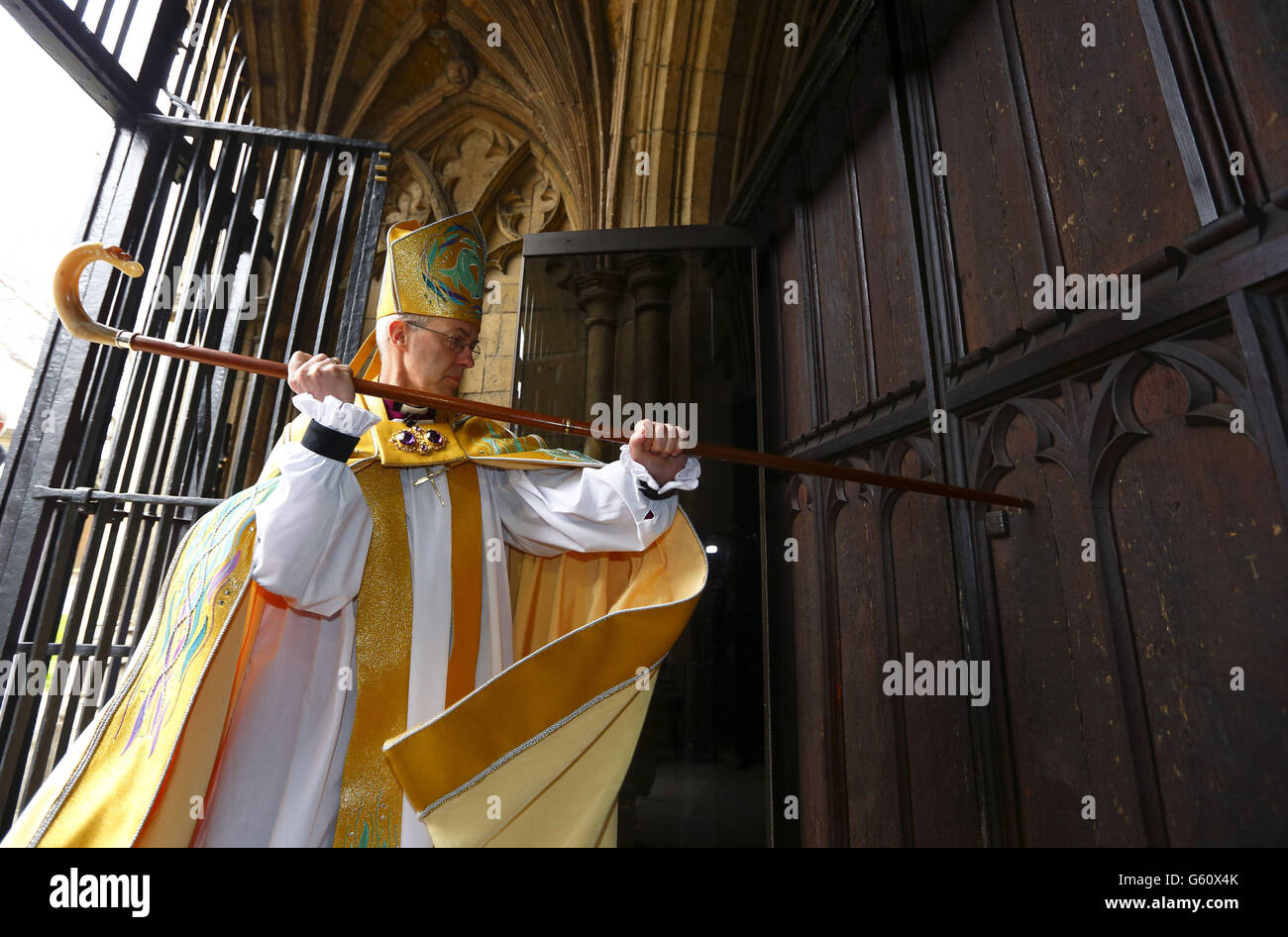 L'Arcivescovo di Canterbury, il Reverendissimo Justin Welby, colpisce tre volte sulla porta Ovest della Cattedrale di Canterbury con il suo staff pastorale prima della sua intronizzazione. Foto Stock