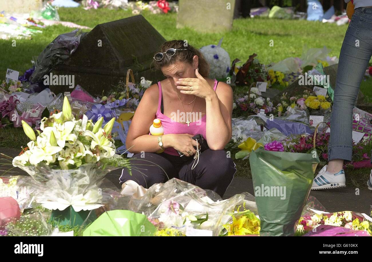 I membri del pubblico guardano i fiori posati nei terreni della Chiesa di Sant'Andrea a Soham, Cambridgeshire in memoria delle studentesse assassinate Holly Wells e Jessica Chapman. Foto Stock