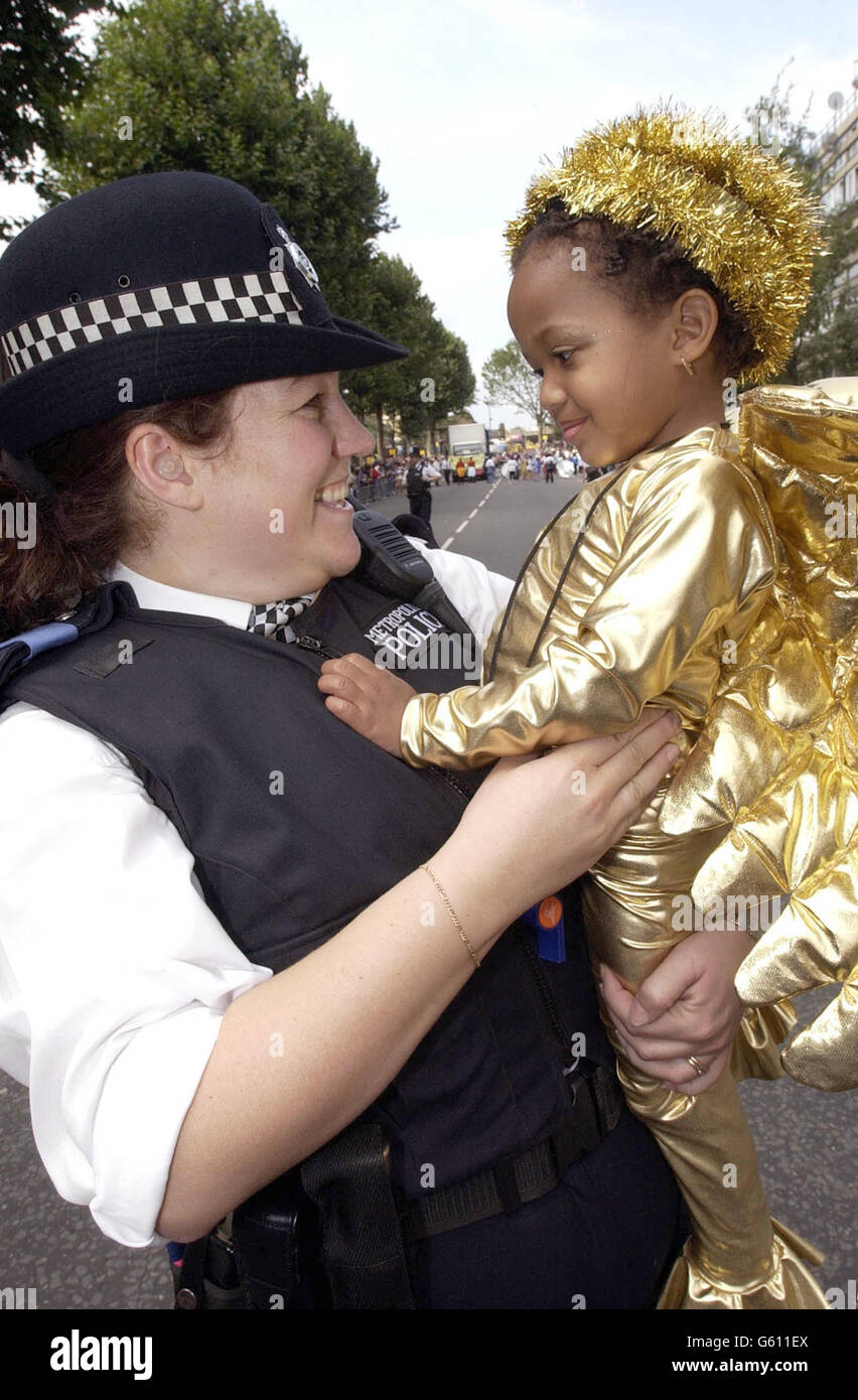 Rebecca Carnegie, 2, di Harrow, riceve un bacio da WPC Emma Cooney al Notting Hill Carnival di Londra. Una portavoce della polizia ha detto che 10,000 ufficiali sarebbero in servizio nel corso dei due giorni, con 350 steward appositamente addestrati, nel tentativo di prevenire qualsiasi problema. Foto Stock