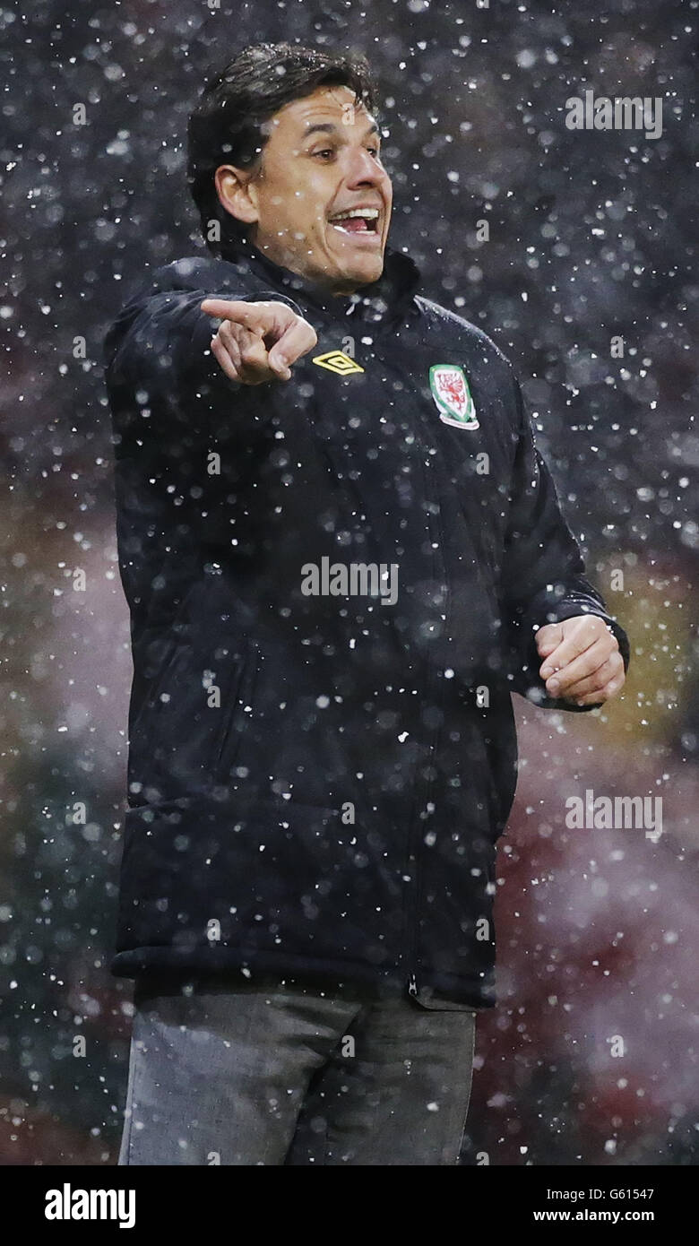 Calcio - Coppa del mondo FIFA 2014 Qualifiche - Gruppo A - Scozia / Galles - Hampden Park. Il manager del Galles Chris Coleman dirige i suoi giocatori attraverso la neve durante il campionato mondiale di qualificazione 2014 ad Hampden Park, Glasgow. Foto Stock