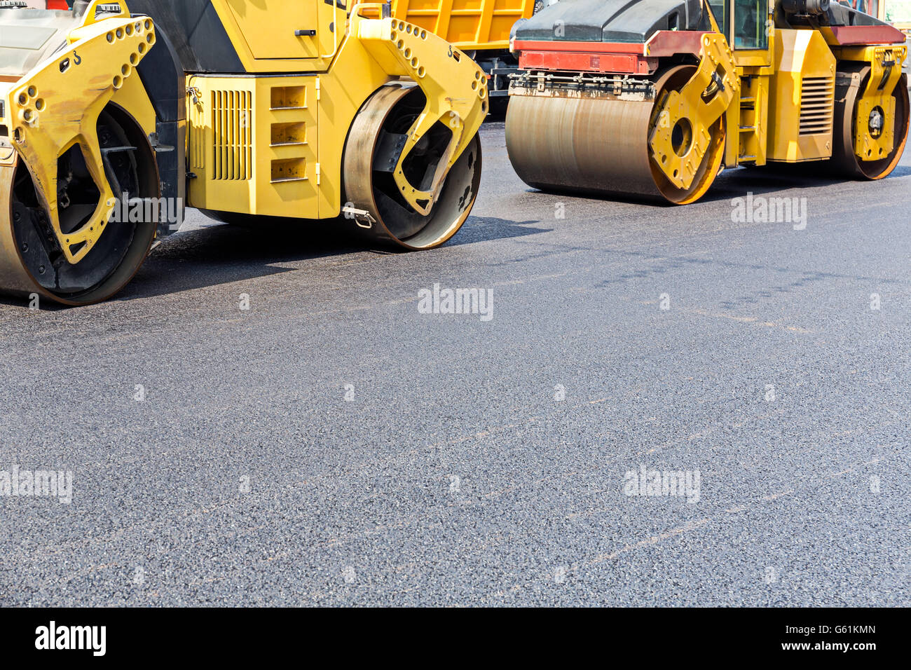 Strada di vapore rulli compattatori di asfalto fresco durante la guida su strada con lavori di riparazione Foto Stock