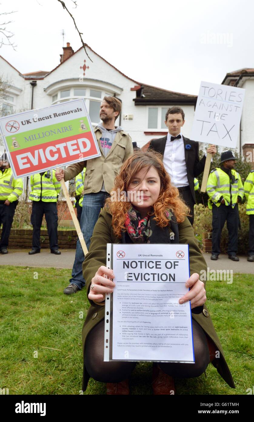 Un giovane protestante tiene un avviso di sfratto come parte di un grande gruppo di dimostranti del gruppo di azione diretta UK Uncut riunirsi fuori di quello che si ritiene essere la casa di Lord Freud, a Langbourne Avenue in Highgate, a nord di Londra. Foto Stock