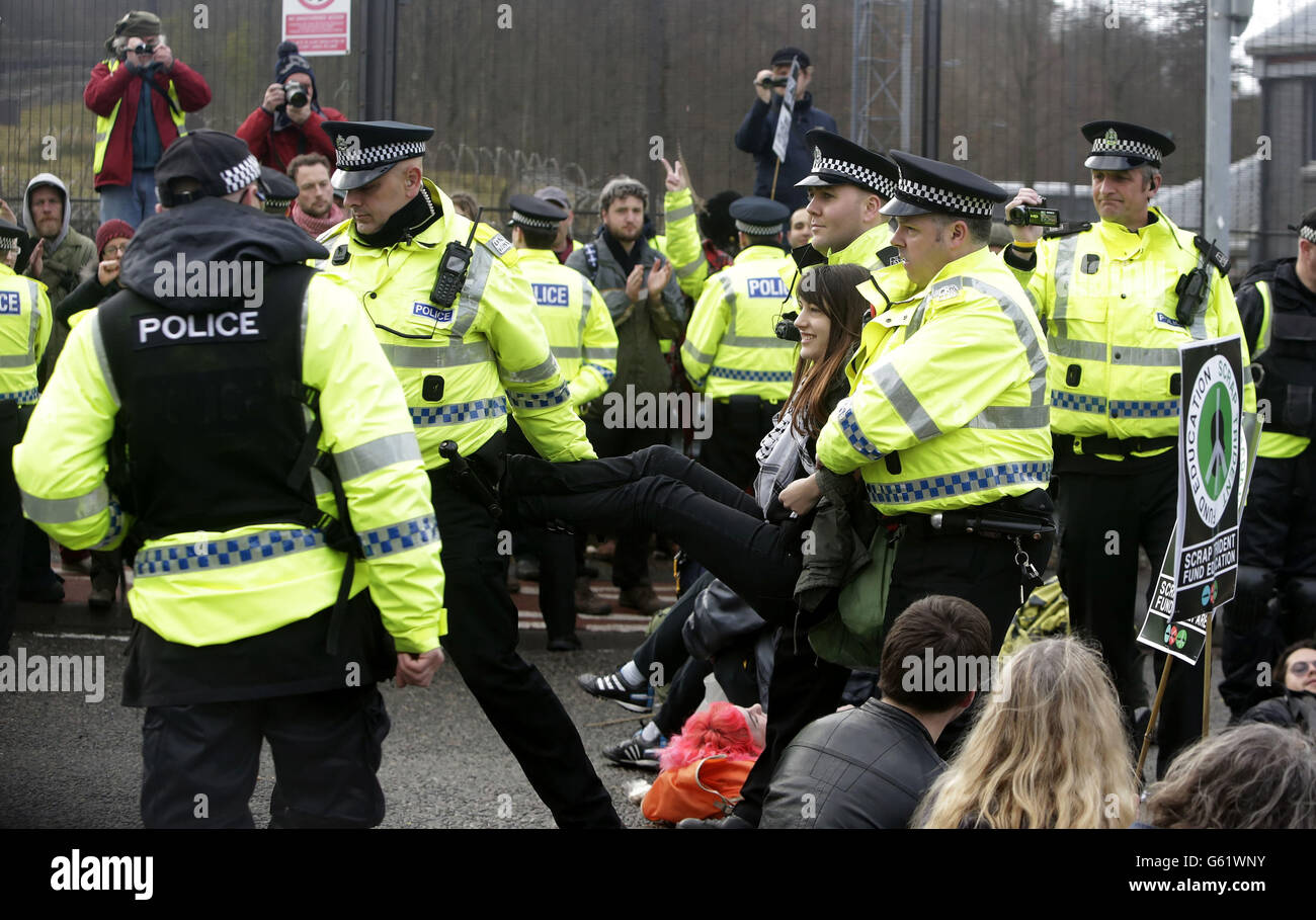 I manifestanti sono mossi dalla polizia in una zona di blocco della base navale di Faslane in Scozia durante una dimostrazione anti Trident. Foto Stock