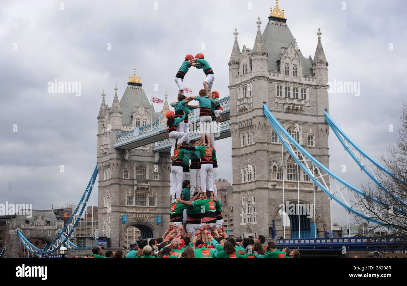 I membri del team Human Towers Castellers de Vilafranca formano successivamente i livelli più piccoli salendo i corpi di ogni strato per montare le spalle del livello precedente fino a quando la torre non è completa al Tower Bridge di Londra. Le Torri umane, una consuetudine unica catalana, sono state costruite durante le celebrazioni e i festival della città di Barcellona per trecento anni e sono descritte dall'UNESCO come un patrimonio culturale immateriale dell'umanità. Foto Stock