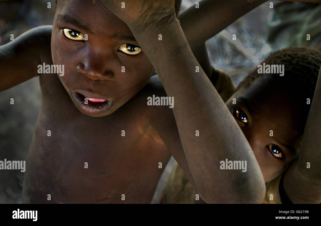 I bambini si affacciano nel villaggio di Kanyopola, nel Malawi centrale, colpito dalla carestia. Le Nazioni Unite attualmente stimano che 18.4 milioni di persone sono vittime di fame nella regione dell'Africa meridionale. Foto Stock