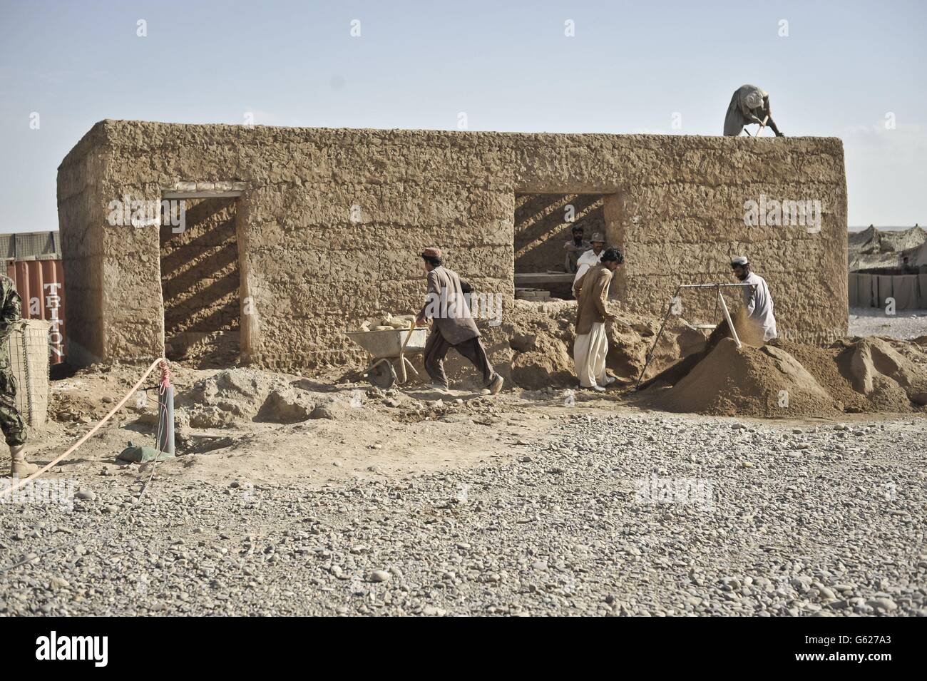 Una visione generale degli operai edili locali afghani che eruttano un edificio alla base di Patrol Clifton, ora rinominato PB Oqab, poiché ospita solo soldati dell'esercito nazionale afghano e viene costruito per soddisfare le loro specifiche esigenze, mentre le forze ISAF iniziano a affidare basi e a lasciare l'Afghanistan nel 2014. Foto Stock
