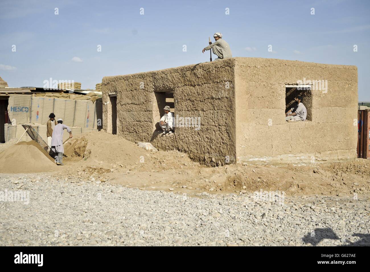 Una visione generale degli operai edili locali afghani che eruttano un edificio alla base di Patrol Clifton, ora rinominato PB Oqab, poiché ospita solo soldati dell'esercito nazionale afghano e viene costruito per soddisfare le loro specifiche esigenze, mentre le forze ISAF iniziano a affidare basi e a lasciare l'Afghanistan nel 2014. Foto Stock