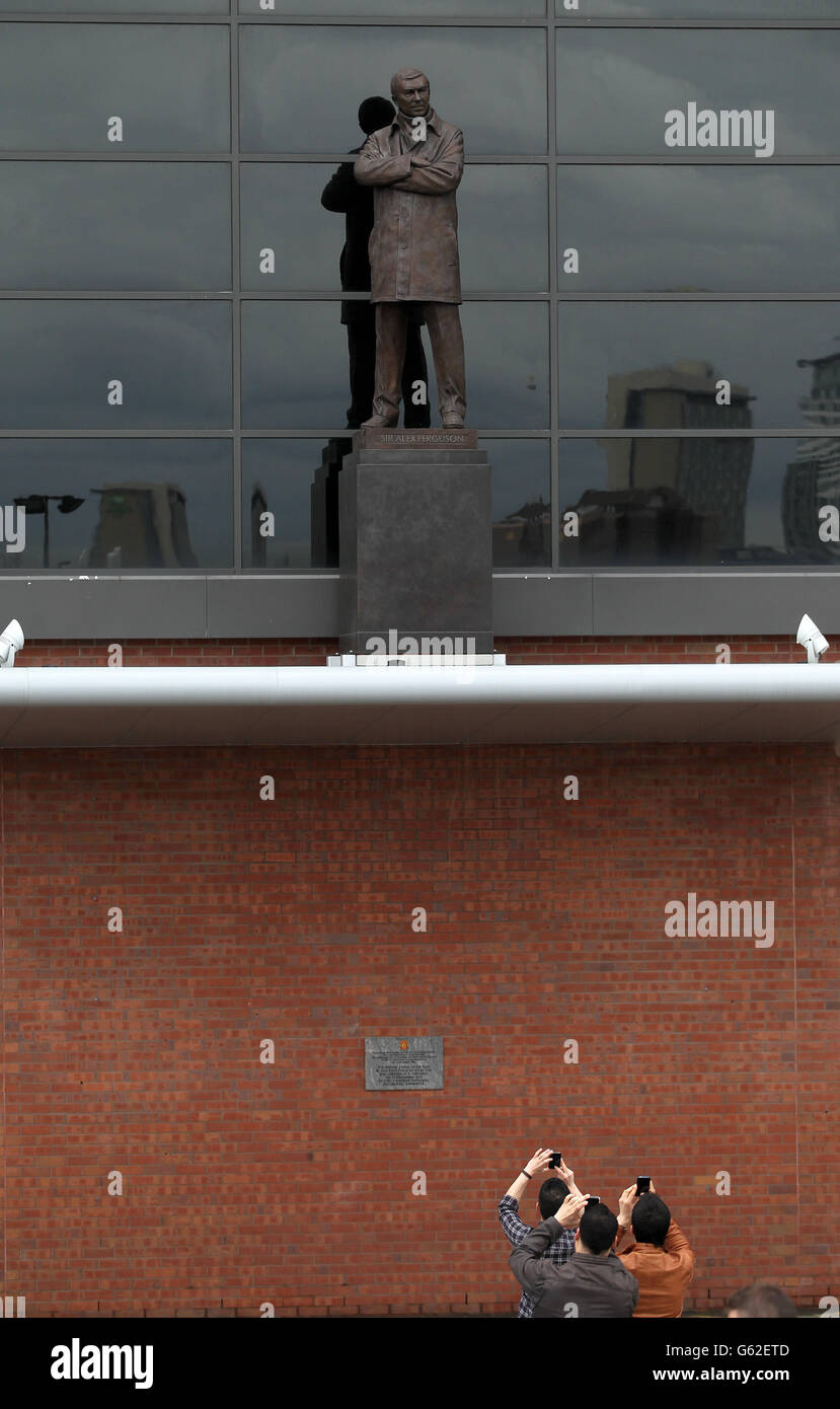 Persone che scattano foto della statua di Sir Alex Ferguson fuori da Old Trafford il giorno in cui Sir Alex Ferguson annuncia i suoi ritiri dalla direzione. Foto Stock