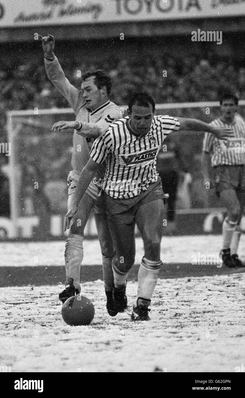 Il Mel Sterland di Sheffield Wednesday rimbalza sulla palla dopo aver controllato Paul Moran (a sinistra) e averlo portato fuori dal giocatore Tottenham, l'arresto sta attaccando corsa durante la partita di Snowbound League Division uno a Hillsborough. 04/02/04: Il Mel Sterland di Sheffield Wednesday rimbalza sulla palla dopo aver controllato Paul Moran di Tottenham (a sinistra), durante la partita di campionato Snowbound a Hillsborough: Sterland, che ha fatto un totale di 344 apparizioni di campionato e coppa in 11 anni a Hillsborough, ora lavora come agente di giocatore come partner in Premier Sports UK . Foto Stock