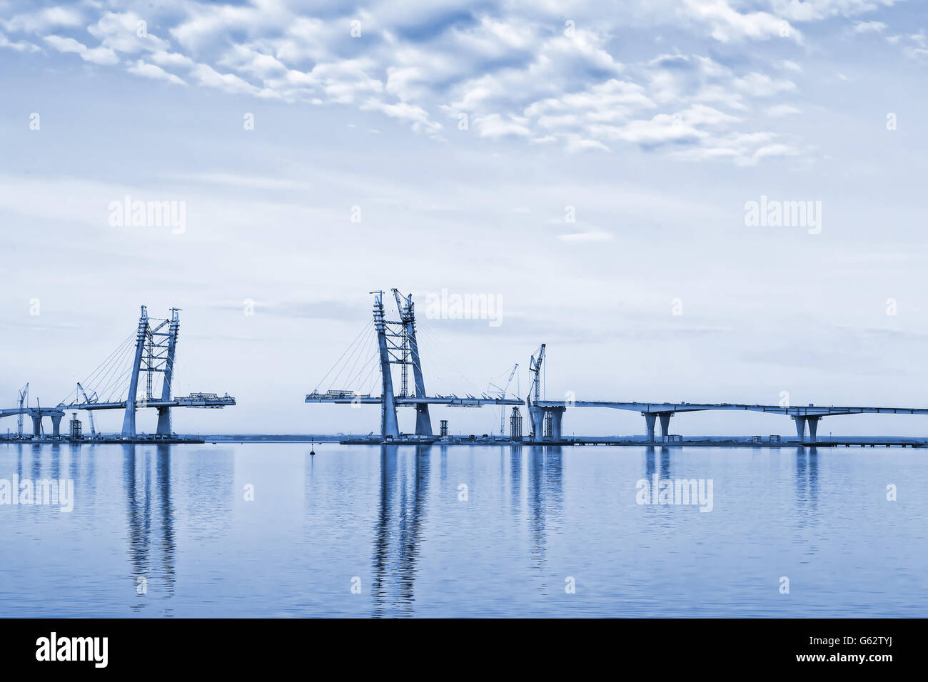 Dai toni monocromatici paesaggio con nuvole, mare e costruzione di ponti Foto Stock