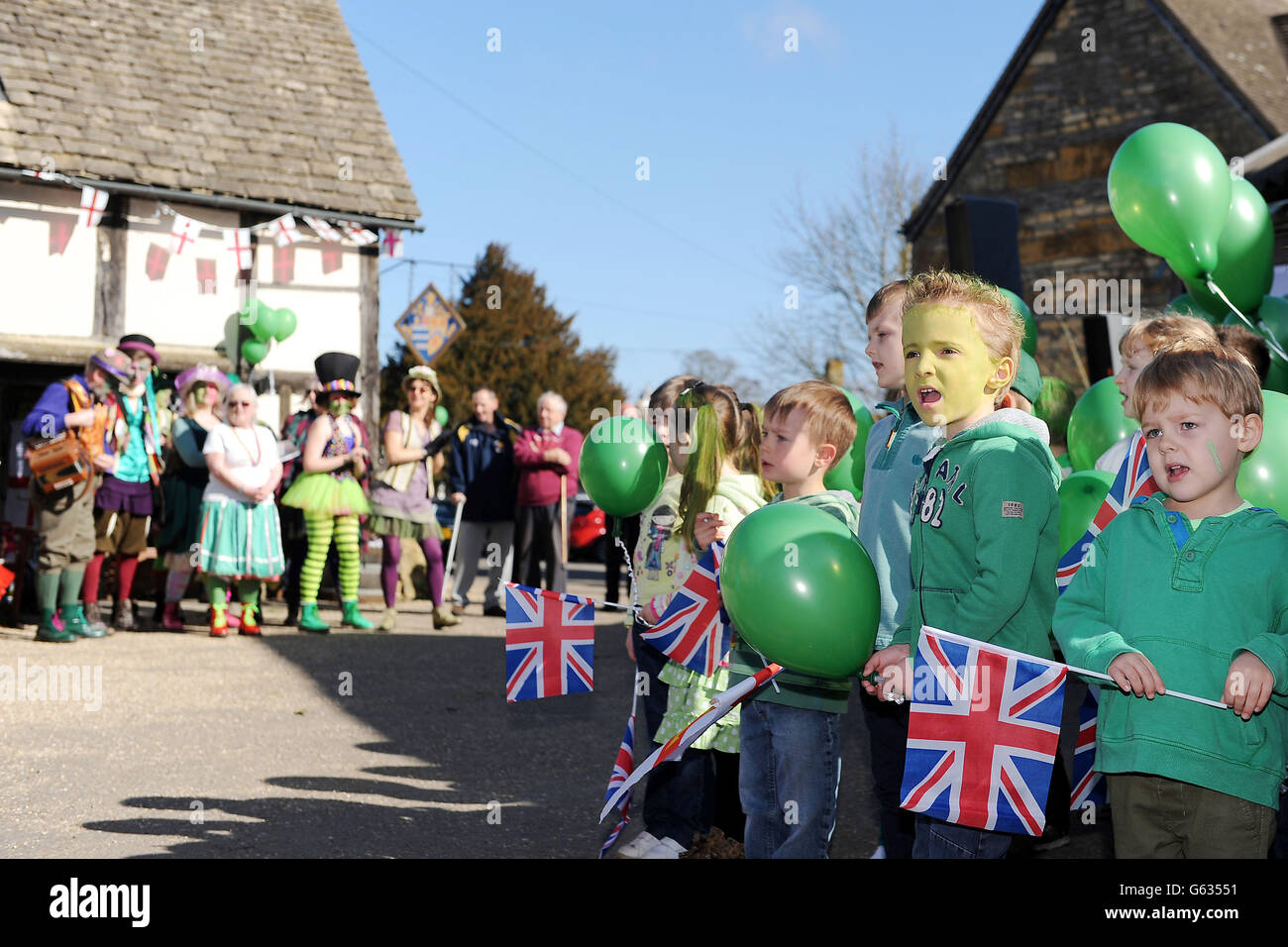 I bambini della Bretforton First School celebrano il lancio della stagione degli asparagi britannici. Una serie di appassionati di asparagi si riuniscono oggi - St George's Day - per celebrare eccentricamente l'inizio della stagione degli Asparagi Britannici di due mesi, a cominciare dalla Grande corsa degli Asparagi Britannici. Foto Stock