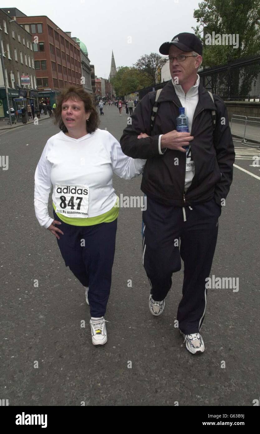 Artrite soffre, Annette Schuster, 44, da Phoenix, Arizona, U.S.A, dopo aver terminato la Maratona di Dublino Adidas, in tredici ore e mezza dopo aver iniziato a mezzanotte a Dublino, Repubblica d'Irlanda. *...con lei c'è il compagno sofferante di arthritus, Jeff Wilde, che ha camminato con Annette durante tutta la gara, da cui la signora Schuster ha raccolto 4,200 dollari per arthritus Foundation Joints in Motion. Frederick Cherono, atleta keniota di 23 anni, ha battuto la gara di oltre 8,000 corridori per vincere la maratona. Foto Stock