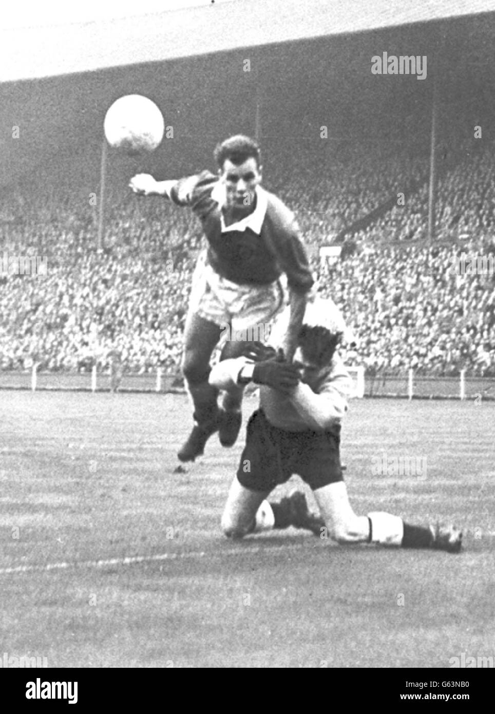 Il portiere dell'Inghilterra Ray Wood si copre involontariamente - e chi non avrebbe con la maggior parte del centro del Galles avanti John Charles torreggiare su di lui, durante un raid sul gol dell'Inghilterra nella partita di calcio internazionale a Wembley, Londra. 21/02/04: L'ex attaccante di Leeds, Juventus e Galles è morto all'età di 72 anni. Foto Stock