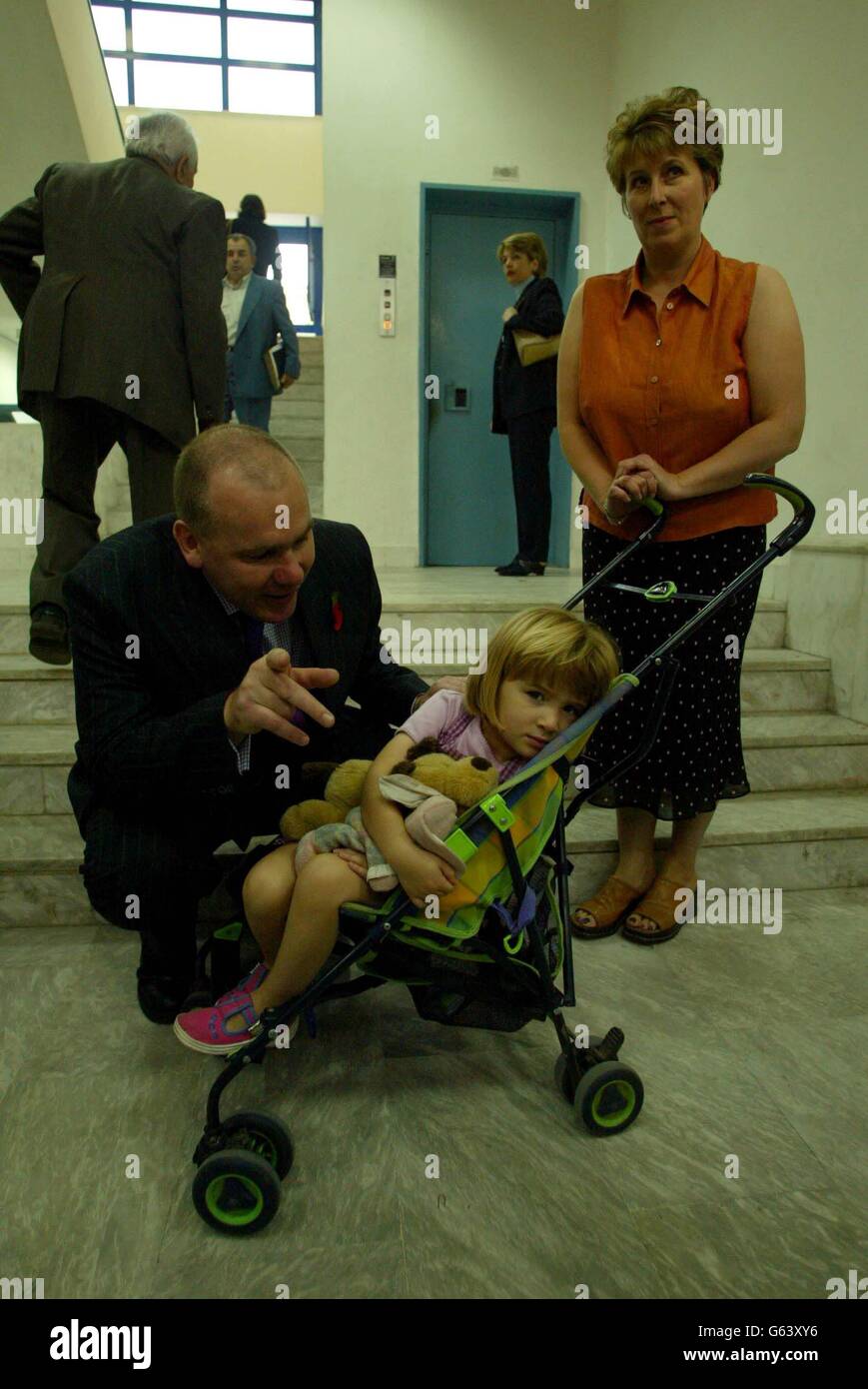 Steve Rush da Caterham, Surrey con la sua figlia di tre anni Isla e la moglie Jenny arrivano a Kalamata Court, Grecia per l'inizio del appello dei planespotters. *...il gruppo si sta preparando a scommettere sulle loro pene esistenti - tre anni in carcere per i sei condannati per spionaggio e un anno di condanne sospese per i sei ritenuti colpevoli di aver aiutato e di aver abitato - mentre si sforzano di cancellare i loro nomi. Foto Stock