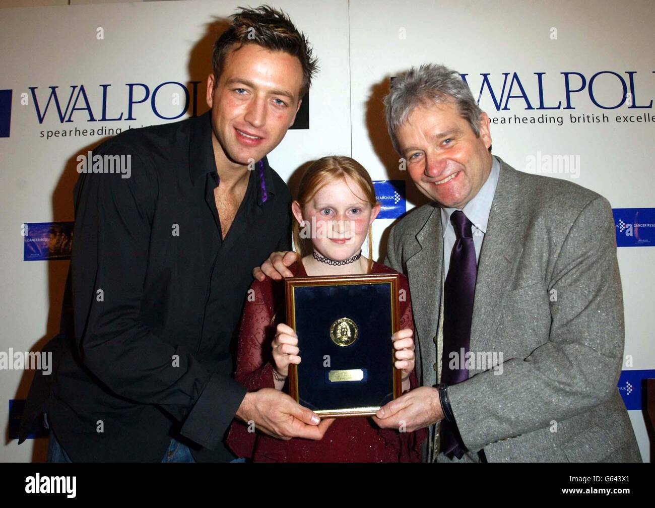 Il rugby inglese Dan Luger presenta il Premio umanitario Walpole 2002 al Chief Executive di Cancer Research UK Sir Paul Nurse, accompagnato da Ainne Ward, 10 anni, di Brighton, sopravvissuto a una rara forma di cancro agli occhi, *.. Durante una cerimonia alla New Armouries, HM Tower di Londra. Il vincitore dell'anno scorso è stato il Dipartimento dei vigili del fuoco di New York. Foto Stock