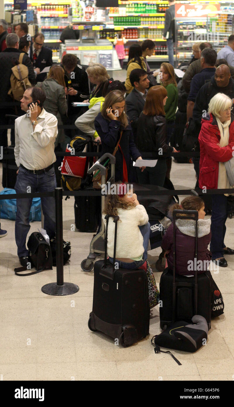 I passeggeri attendono al Terminal uno dopo che un aereo della British Airways ha dovuto effettuare un atterraggio di emergenza all'aeroporto di Heathrow. Foto Stock