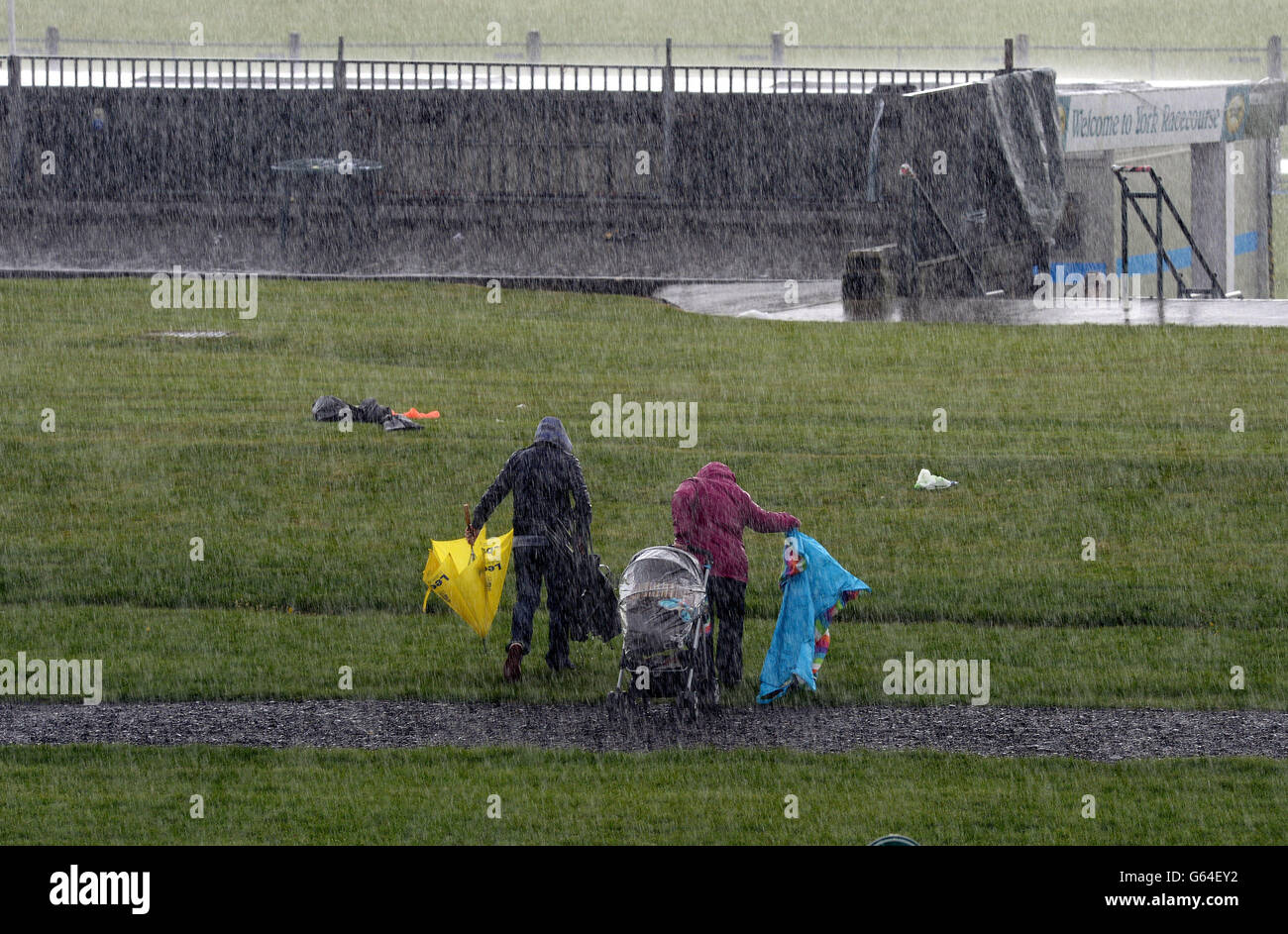 La pioggia torrenziale spinge i corridori fuori dall'ippodromo per cercare rifugio durante il Betfred Dante Stakes Day del Dante Festival 2013 all'ippodromo di York. PREMERE ASOCATION Photo (Foto DI ASSOCAZIONE). Data immagine: Giovedì 16 maggio 2013. Guarda la storia della Pennsylvania RACING York. Il credito fotografico dovrebbe essere: John Giles/PA Wire Foto Stock