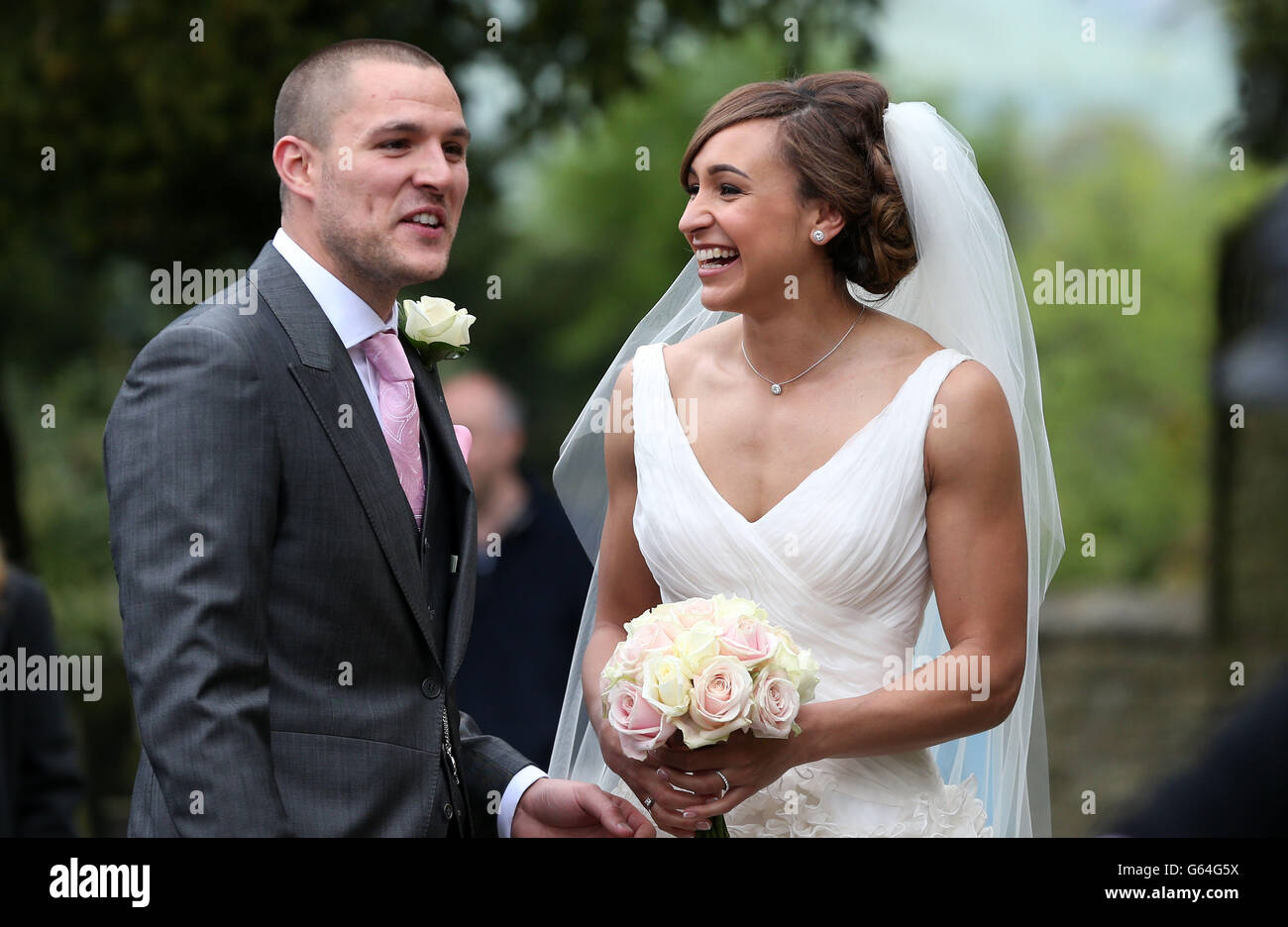 La medaglia d'oro olimpica Jessica Ennis posa per i media in attesa dopo aver sposato Andy Hill a St Michael e All Angels Church, Hathersage, Derbyshire. Foto Stock