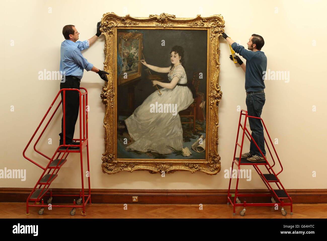(Da sinistra a destra) i gestori d'arte Peter Belling e Simon Lawlor appendono il "Ritratto di Eva Gonzales" di Edouard Manet, mentre quattro dipinti impressionisti vengono restituiti alla Hugh Lane Gallery, Dublino, dalla National Gallery di Londra. Foto Stock