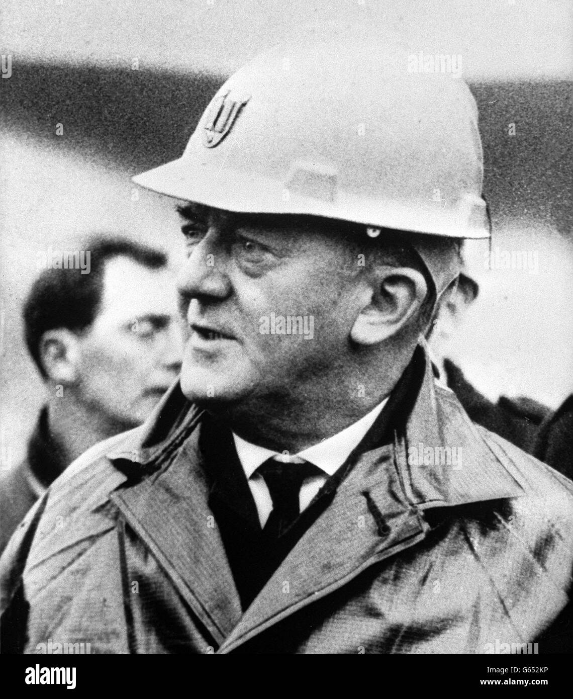 Indossando un casco protettivo bianco e un impermeabile nero, Lord Justice Edmund Davies, presidente del tribunale d'inchiesta sul disastro della punta di carbone di Aberfan. Foto Stock