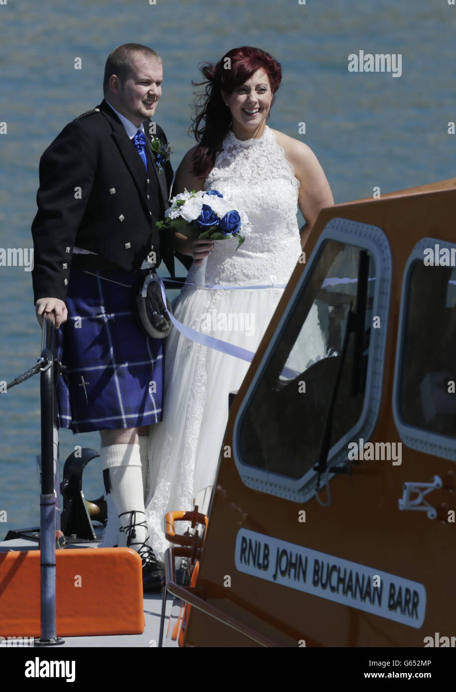 I volontari della Royal National Lifeboat Institution (RNLI) John Connor e Kirstyn Howle si sposano sulla nave di salvataggio di Portpatrick RNLB John Buchanan Barr in una cerimonia umanistica. Foto Stock