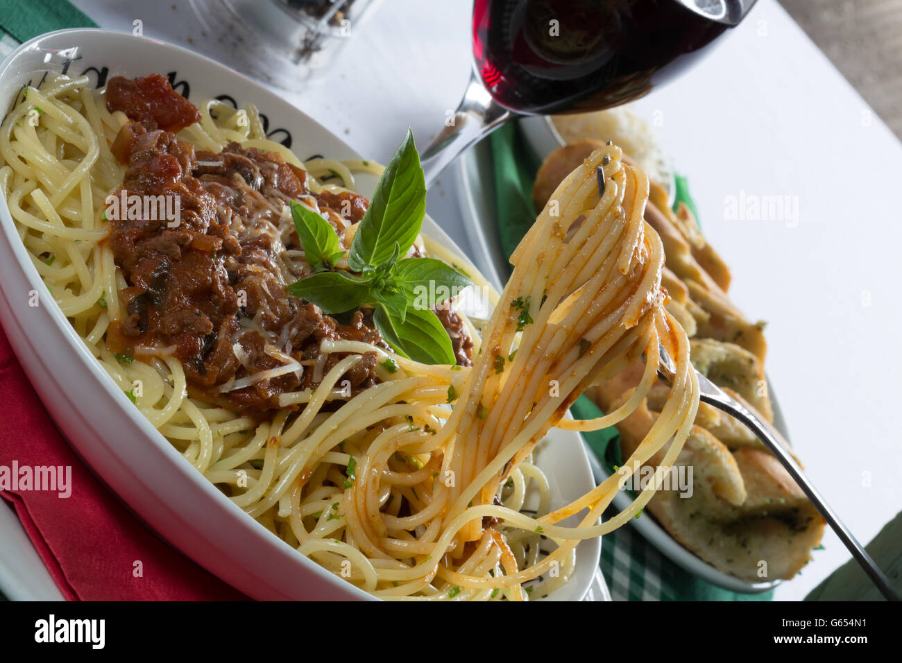 Italiano tradizionale piatto di spaghetti alla bolognese/bolognese servita con pane all'Aglio/Baguette e parmigiano grattugiato. Foto Stock