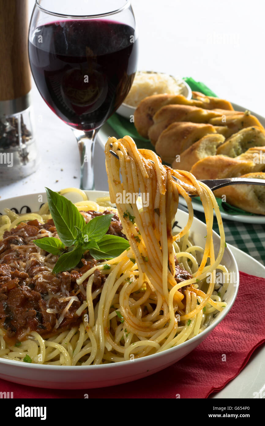 Italiano tradizionale piatto di spaghetti alla bolognese/bolognese servita con pane all'Aglio/Baguette e parmigiano grattugiato. Foto Stock