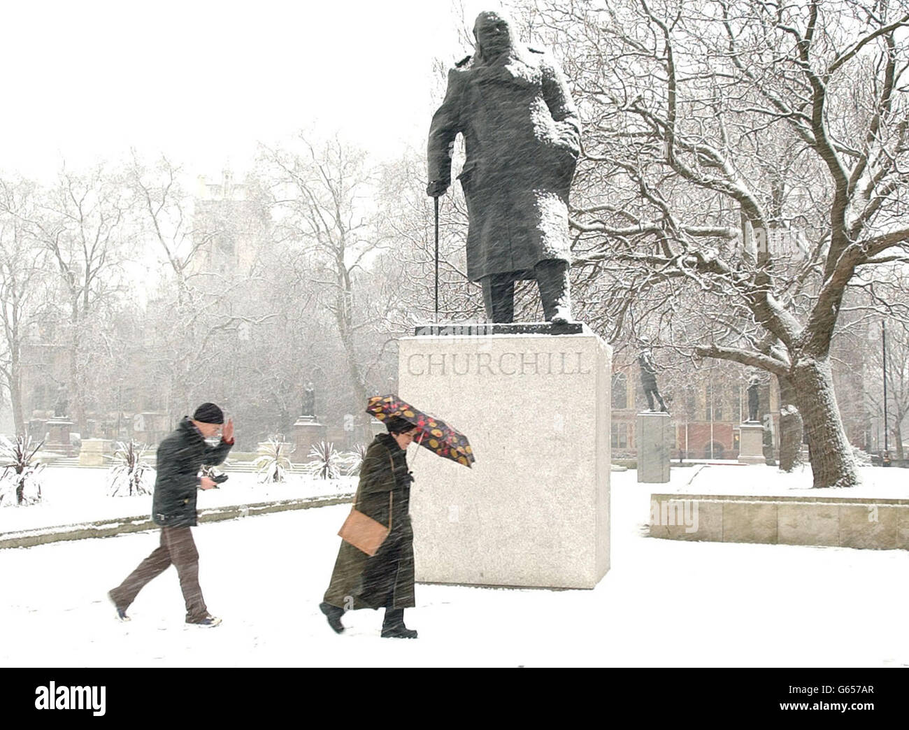 I pedoni passano accanto alla statua di Winston Churchill in Parliament Square, nel centro di Londra, mentre una banda di sciasoni di neve colpiti e mancati colpì le parti orientali del Regno Unito. Durante una notte di gelo pesante, le temperature sono affondate come meno 8C a Farnborough, Hampshire. * ... e Hawarden nel Galles nord-orientale e immerso a meno 16C nella città delle Highland di Aviemore. Foto Stock