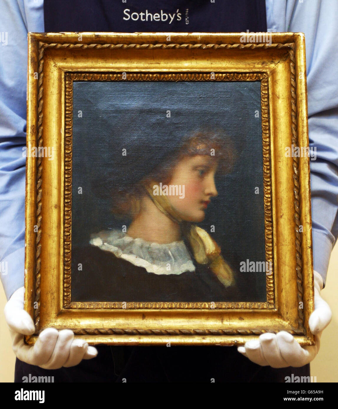 Un portiere alla casa d'aste di Sotheby a Londra detiene 'Letty'. Il dipinto di Lord Leighton sarà venduto a Sotheby's il 16 dicembre 2002 con un prezzo di guida di 100,000-150,000 libbre come parte della collezione Charles e Barbara Robertson. Foto Stock