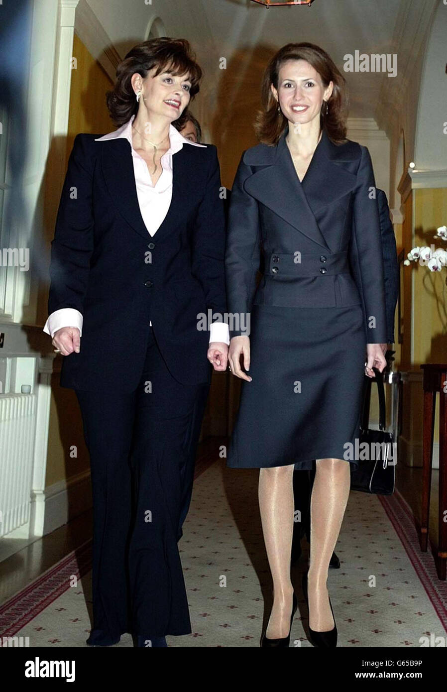 Cherie Blair (a sinistra), moglie del primo ministro britannico Tony Blair, scorta Asma al-Assad, la moglie del presidente siriano Bashar Assad lungo un corridoio all'interno di 10 Downing Street all'inizio della visita ufficiale di Assad in Gran Bretagna. Foto Stock
