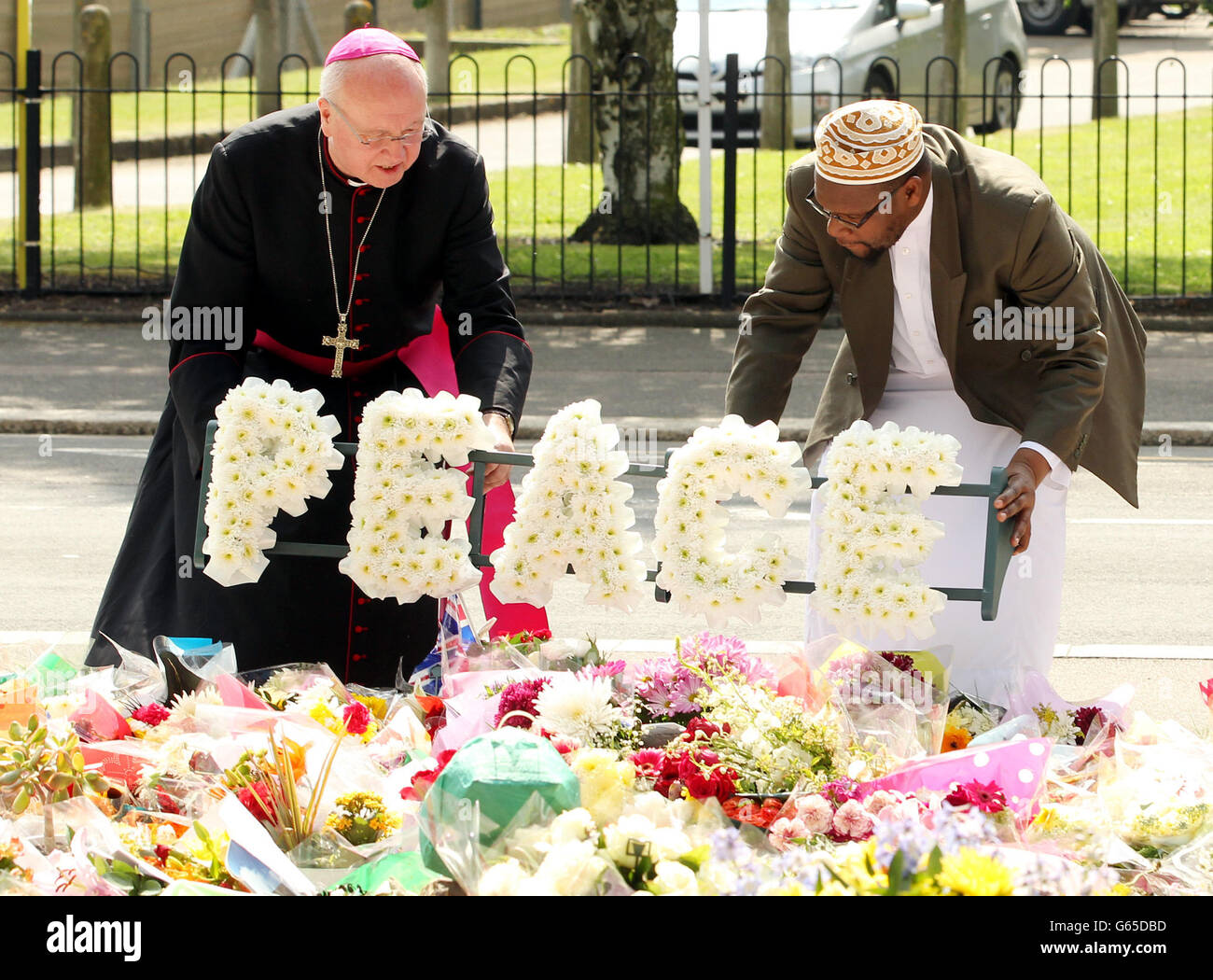 L'ex arcivescovo di Southwark, Kevin McDonald (a sinistra) e Imam Ali Omar posero una corona di pace fuori dalle caserme di artiglieria reale, a Woolwich, a est di Londra, vicino alla scena dove il batterista Lee Rigby fu assassinato. Foto Stock