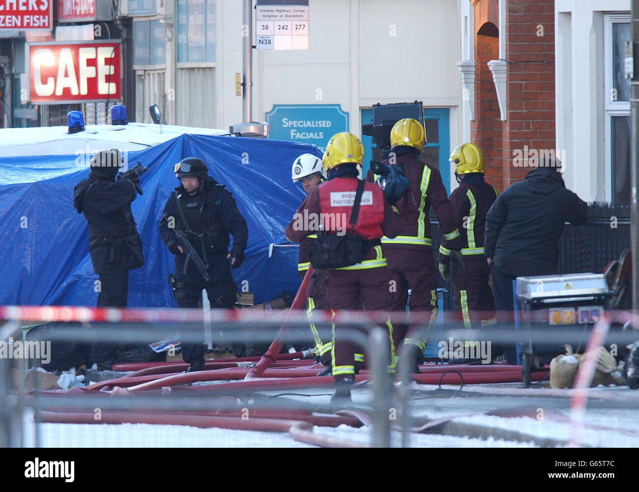 La polizia armata tiene la guardia mentre i vigili del fuoco affrontano una briciolatura dalla casa al centro dell'assedio di Hackney, a est di Londra. Il comandante Bob Quick ha precisato tre possibili scenari che potrebbero essersi verificati a seguito dell'incendio. * ha detto che il pistolero può essere morto o essere stato gravemente incapace, o c'era la possibilità che si nascondesse in parte dell'edificio. LA FACCIA DELL'UFFICIALE DI POLIZIA PIXELATED SU RICHIESTA DEL NUOVO CANTIERE DELLA SCOZIA Foto Stock