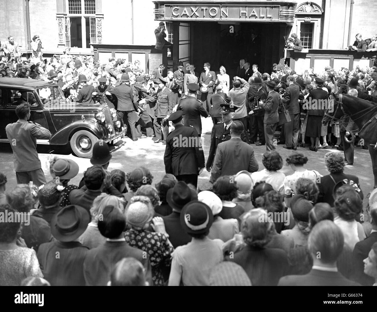 La polizia lotta per trattenere la folla e la stampa cameramen intorno all'ingresso di Caxton Hall, Westminster, Londra, mentre il ministro degli Esteri britannico, Anthony Eden, di 55 anni, parte con la sposa dopo il matrimonio presso la sede del registro. La sposa, sig.ra Clarissa Spencer Churchill, 32 anni, è la nipote del primo ministro, sig. Winston Churchill. Foto Stock